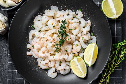 Peeled cooked Shrimps, Prawns in a plate. Black background. top view