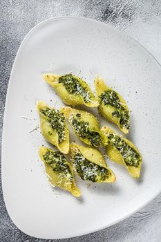 Konkiloni Jumbo shells pasta Conchiglioni stuffed with spinach on a plate. White background. Top view