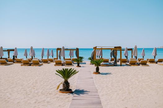 Paralia Platis Gialos beach Mykonos, Petinos beach Mikonos island Greece, luxury beach bed chairs and blue ocean