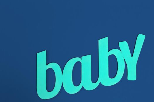 word BABY on classic blue background top view