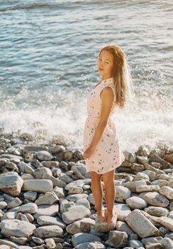 Beautiful girl walking on pebble beach