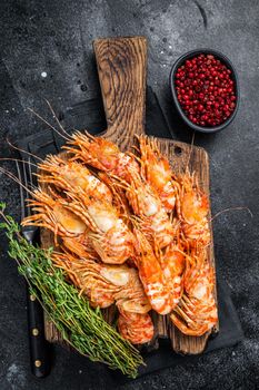 Cooked Greenland Prawn Shrimp on a wooden board. Black background. Top view