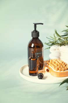 Amber glass bottles with wooden massage brush, eucalyptus leaves and towels. Eco friendly massage and body care concept