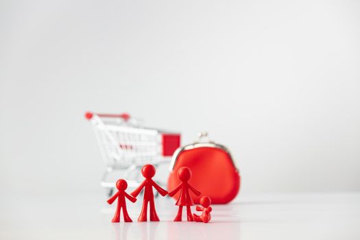 Miniature plastic figures family with children , Metallic shopping cart trolley and Red Coin Purse on light gray background with copy space, shopping and family finance concept