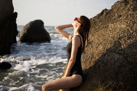 woman in black swimsuit rocks posing oceans