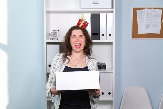 Concept of dismissal from work. Happy woman with carton box with her stationery stuff, girl was fired from her job.