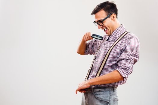 Nerdy man looking in his pants magnifying glass