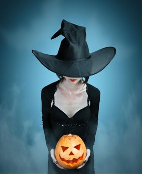 Mystery witch with Halloween pumpkin