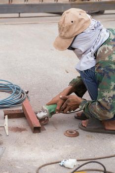 worker using grinder to grinding metal