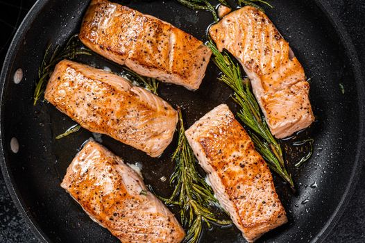 Grilled Salmon Fillet Steak in a pan. Black background. Top view