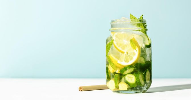 Detox infused water. Refreshing homemade cocktail summer drink, selective focus. Sunny day shadows, banner