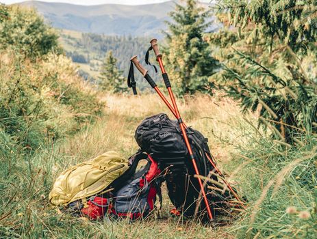 Trekking sticks and backpacks on mountain