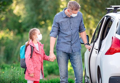 Father driving daughter to school during pandemic