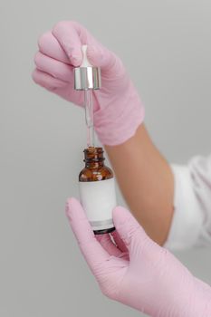 Essential oil dropping from pipette to the bottle. Essence liquid cosmetic. Syrup. Perfume.Aromatherapy.