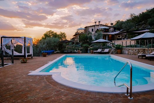Luxury country house with swimming pool in Italy. Pool and old farm house during sunset central Italy.