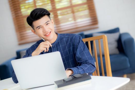 Young asian business man planning working and using laptop computer on desk at home, notes about finance, male study and learning, businessman thinking idea, business and communication concept.