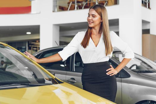 Young woman checking out a new car she is going to buy