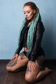 Portrait of a girl with tattoos and dreadlocks