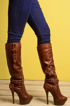 sporty girl in brown high-heeled boots and jeans