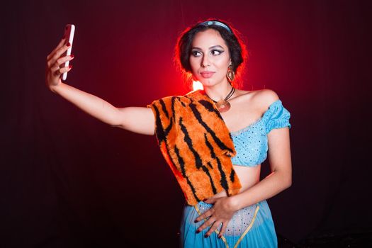 Girl doing selfie with tiger skin, crazy photos. Don't eco friendly lifestyle. Young woman takes pictures of herself in the phone. Life in social networks, narcissism, modern personality. Personality disorder.