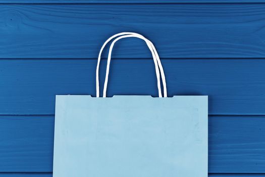 Blue shopping bag on blue background, top view
