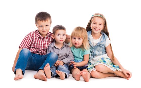 four cute children sitting on the floor