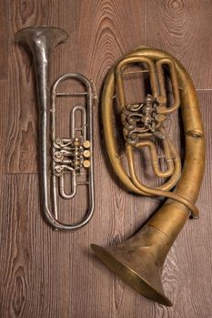  old brass wind instrument and horn  on a wooden background