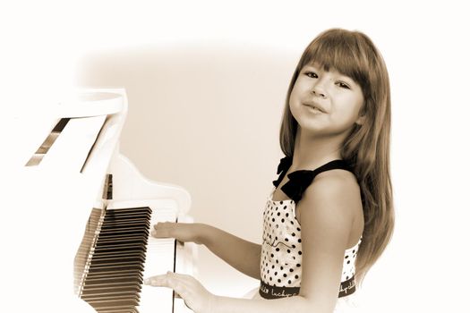 Lovely girl posing at white grand piano