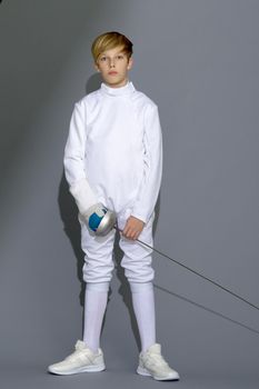 Boy in fencing costume posing with sabre