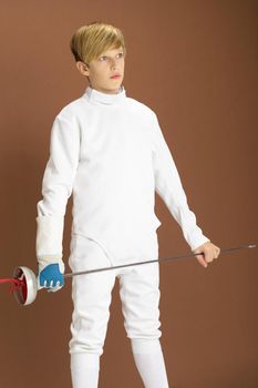 Boy fencer in white fencing costume with rapier