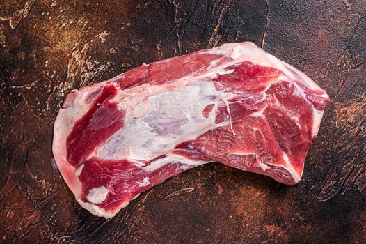 Raw lamb mutton shoulder meat on the bone. Dark background. Top view