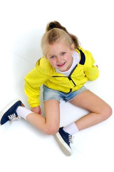 Six years old girl sitting on floor on her knees