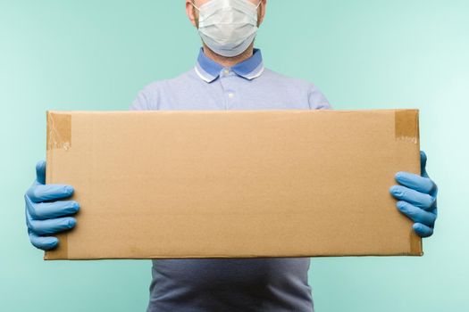 Man holding cardboard boxes in medical rubber gloves and mask.
