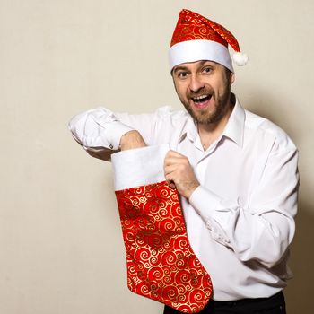 Surprised man in Christmas cap pulls gift out of sock
