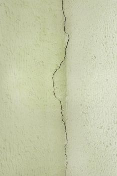 Crack on the old plaster wall surface in the ceiling corner of the building facade texture background