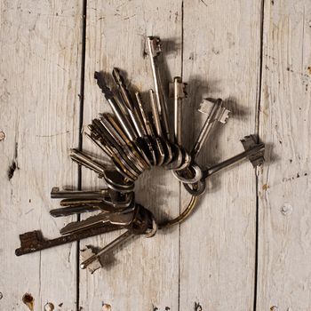 Antique copper keys on old wooden background