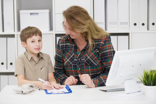 Teacher with a primary school student.Mom in the office with a child