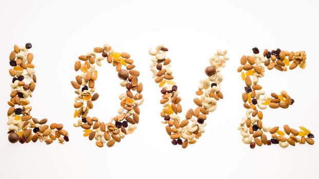 The word love laid out from a mix of nuts on a white background.