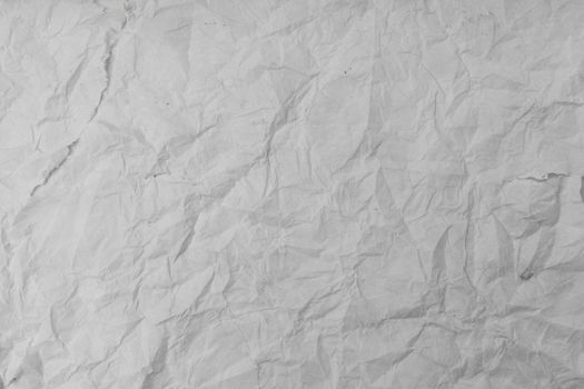 Texture of wet white folded paper on an outdoor poster wall, crumpled paper background.