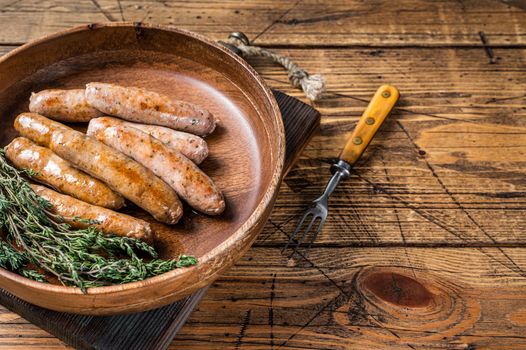 Fried Chorizo and Bratwurst sausages in a wooden plate. wooden background. Top View. Copy space