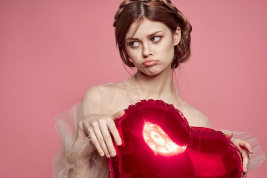 portrait of a woman red heart in the hands of the balloon model studio. High quality photo