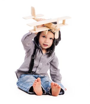 little boy with pilot hat playing toy plane