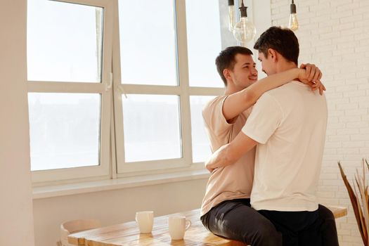 Beautiful cute gay couple, LGBT couple, in bright kitchen