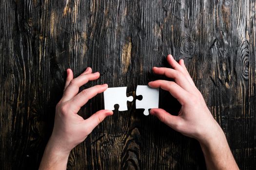 hands with pieces of jigsaw