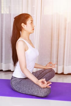 young woman doing yoga exercise isolated on a white background