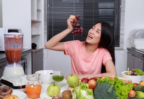 woman eating grape in kitchen room