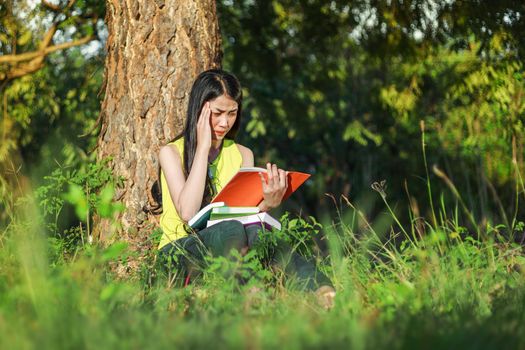 woman in stress situation when reading a book in the park