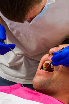 Visiting the dentist, the dentist evaluates the oral cavity and identifies problem areas of the teeth.