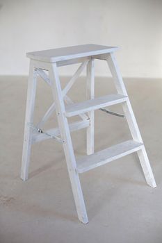wooden ladder in emty white room in front of wall