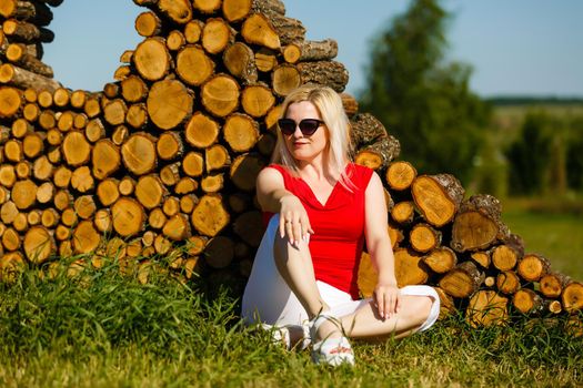 woman sitting against tree in the park on the grass
